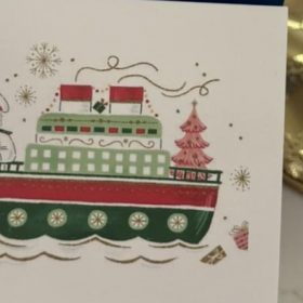 Person writing a handwritten note in a holiday card for holiday card etiquette guide.