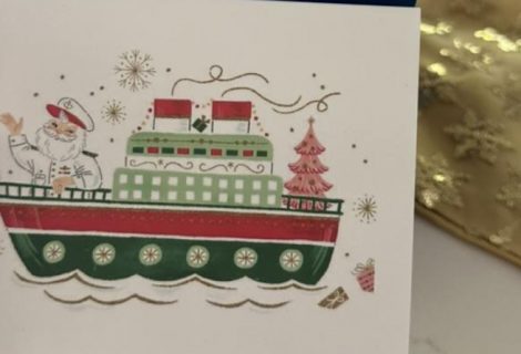 Person writing a handwritten note in a holiday card for holiday card etiquette guide.