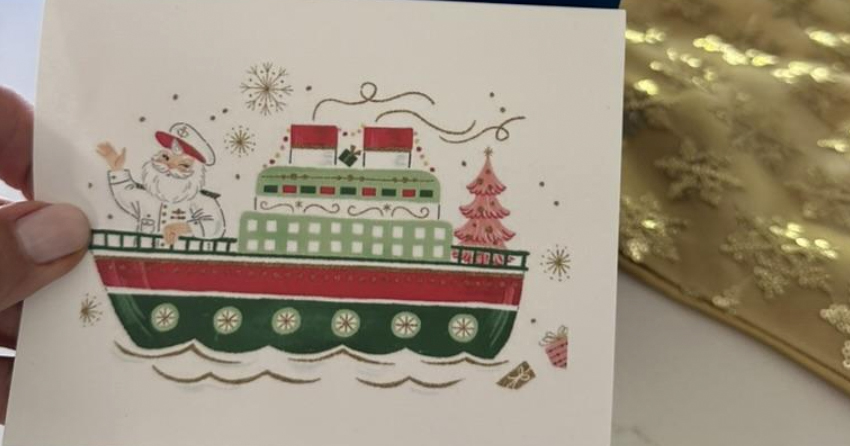 Person writing a handwritten note in a holiday card for holiday card etiquette guide.